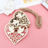 A set of ten wooden heart-shaped hanging ornaments with intricate bird designs on a pink background.