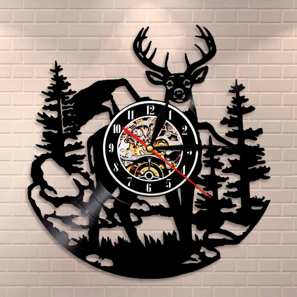 Black silhouette wall clock featuring a deer head and elk antlers against a brick background.