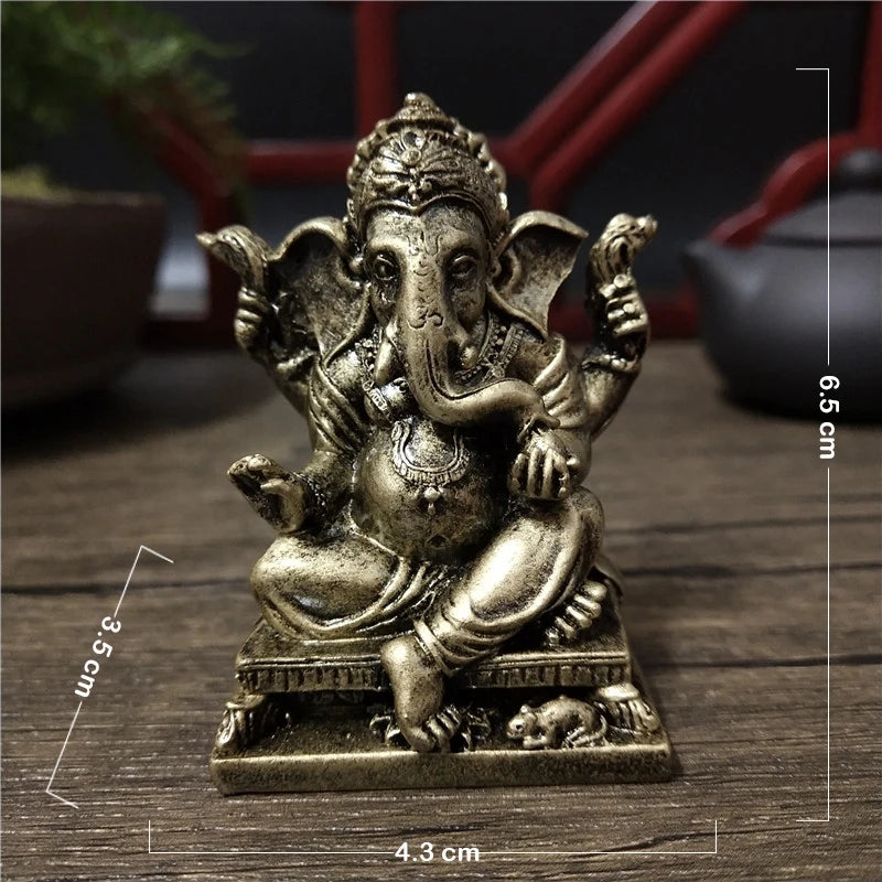 A handcrafted gold-colored resin statue of Lord Ganesha sitting on a pedestal.