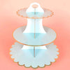 A light blue cardboard cupcake stand with three tiers, featuring gold accents.