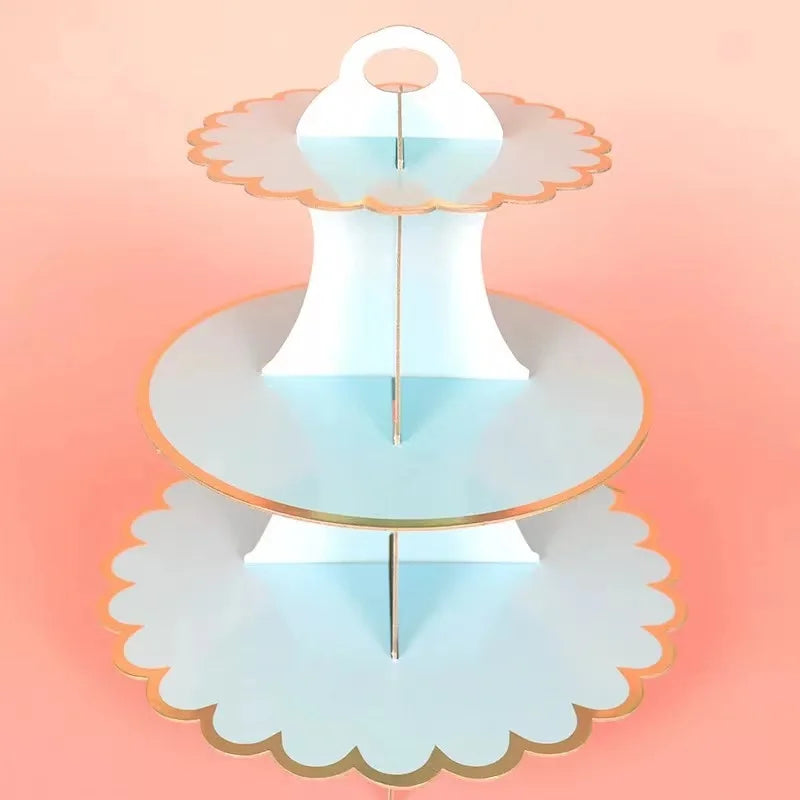 A light blue cardboard cupcake stand with three tiers, featuring gold accents.
