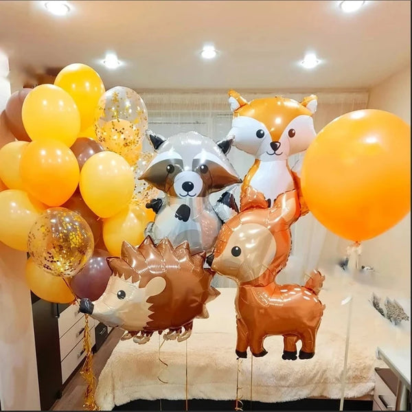 A set of woodland animal foil balloons including a fox, a deer, and a bear, arranged for a party decoration.