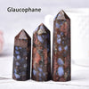 Three dark brown and blue translucent crystal point prisms standing upright on a white surface.