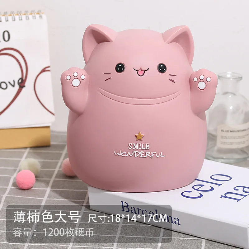 A pink cartoon cat piggy bank with a smiling face sitting on a white box.
