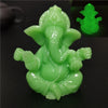 Handcrafted Buddha statue in light green color shown against a dark background.