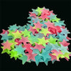 A pile of glow-in-the-dark star wall stickers in various shades of pink, green, and blue.