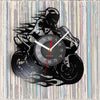 A black silhouette of a motorcycle rider forms the frame around a round vinyl record wall clock.