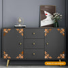 A dark gray cabinet with gold accents and a framed portrait, featuring decorative self-adhesive tiles.
