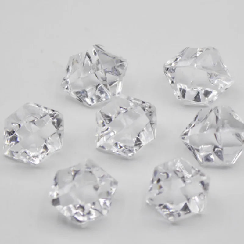 A collection of clear acrylic crystal decorations shaped like various geometric solids for parties