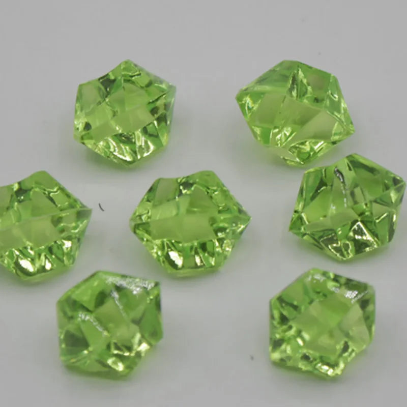 A collection of faceted, light green acrylic crystal decorations for parties.