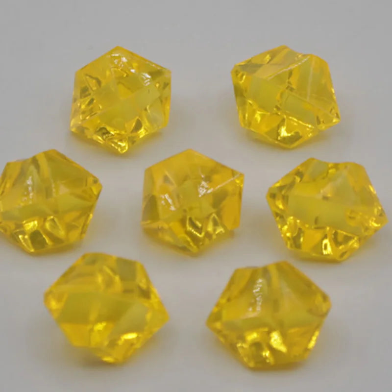 A collection of bright yellow acrylic crystal decorations shaped like pyramids and geometric solids.