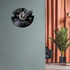 A black vinyl record sports car wall clock mounted on a gray wall.