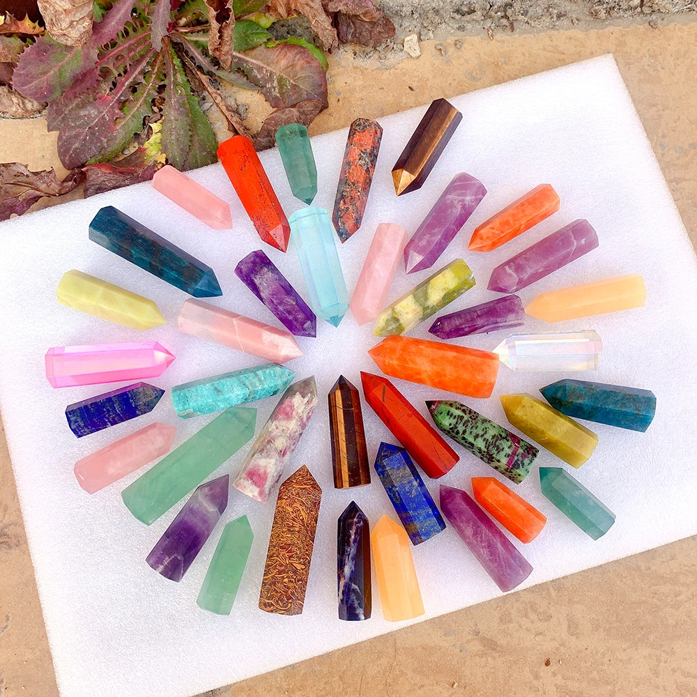 A collection of colorful natural crystal point prisms arranged on a white surface.