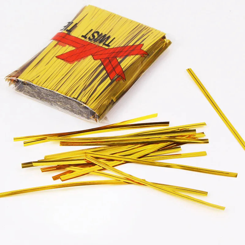 A pack of clear cellophane gift bags with gold twist ties, featuring a red ribbon detail.