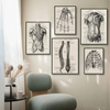 A gallery wall featuring several black and white anatomical drawings of the human body on a beige wall.