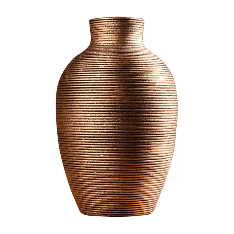 A tall, textured copper-toned ceramic vase with vertical ribbing.
