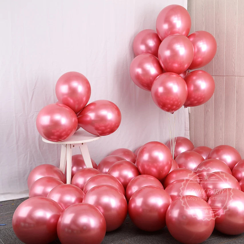 Un grupo de globos rosa y oro rosa dispuestos sobre un fondo blanco.