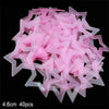 A pile of pink glow-in-the-dark star and moon wall stickers