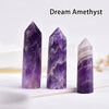 Three purple amethyst crystal points of varying sizes displayed on a white surface.