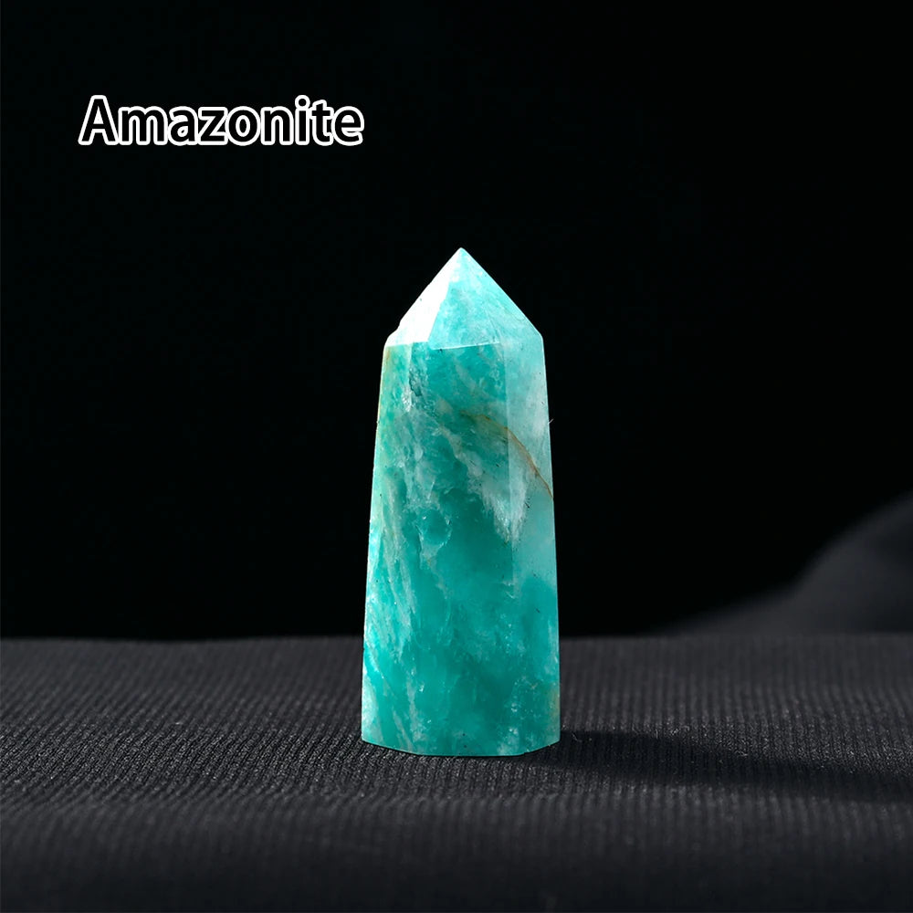 A clear, hexagonal Amazonite crystal point prism tower resting on a dark surface.