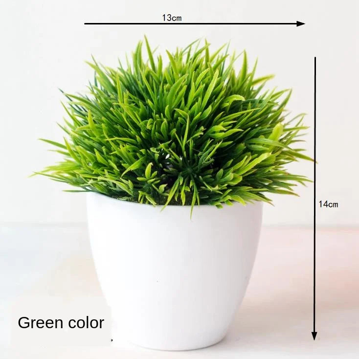 A vibrant green artificial bonsai tree in a white pot, shown from above.