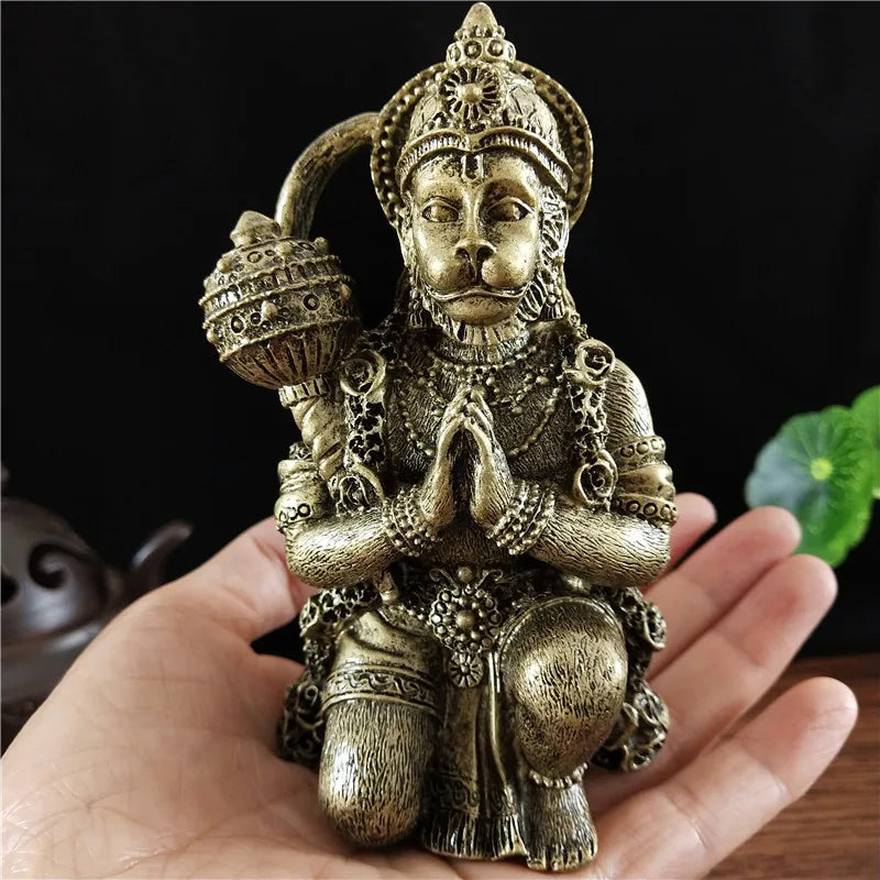 Bronze Hanuman statue figurine of a monkey god held in a praying mudra, displayed in a hand.