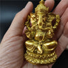 Gold Ganesha statue handcrafted resin figurine held in a hand