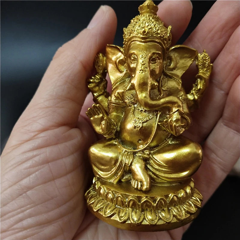 Gold Ganesha statue handcrafted resin figurine held in a hand