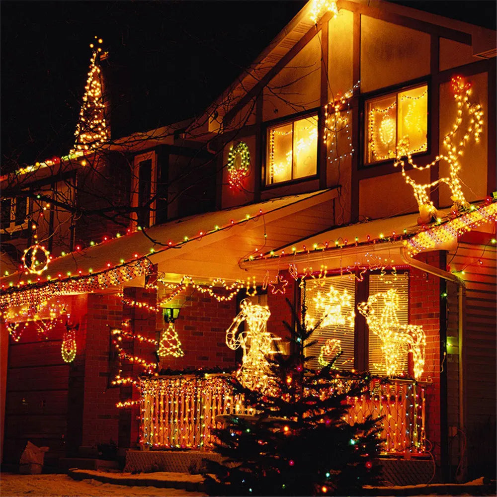 A house decorated with warm yellow LED string lights and holiday lights illuminating the exterior.