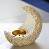 An antique crescent resin incense burner with a textured white body and gold accents sits on a light surface.