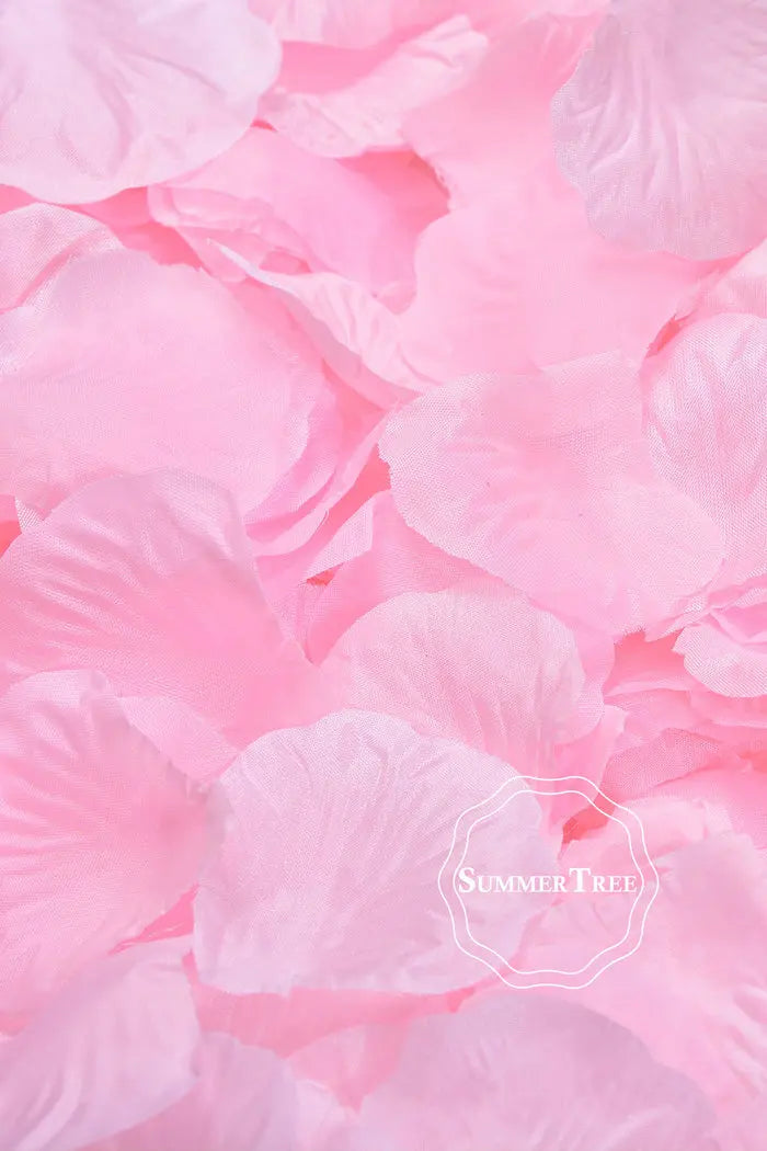 Pink silk rose petals scattered on a surface for weddings and events.