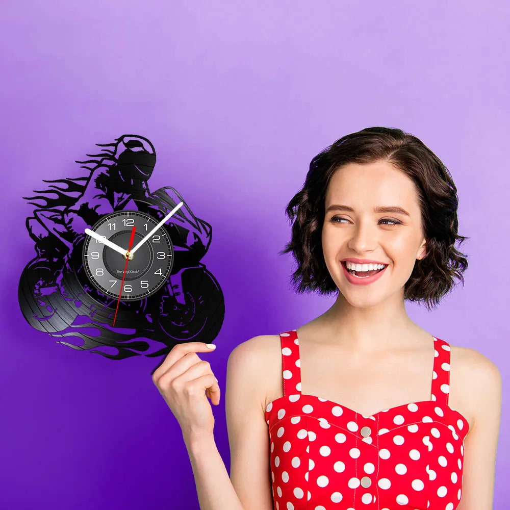 A woman holds a black vinyl record wall clock with a red hand against a purple background.