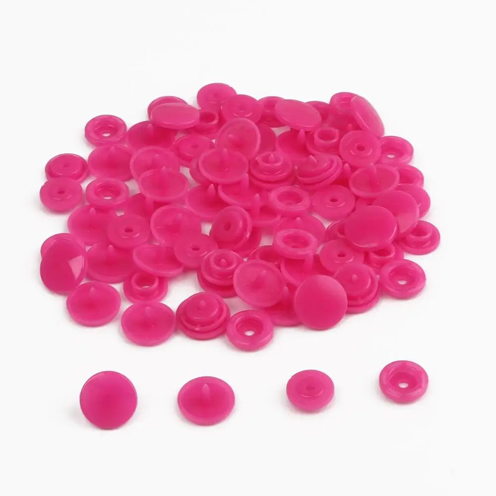 A pile of assorted pink snap buttons, measuring 12mm and 10.5mm, for crafting.