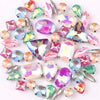 A mix of iridescent glass rhinestones in jelly candy AB colors scattered on a white background.