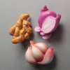A set of three realistic fruit and vegetable fridge magnets in pink and orange tones.