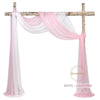 Pink and white sheer chiffon fabric drape hanging on a wooden cross for wedding or event decor