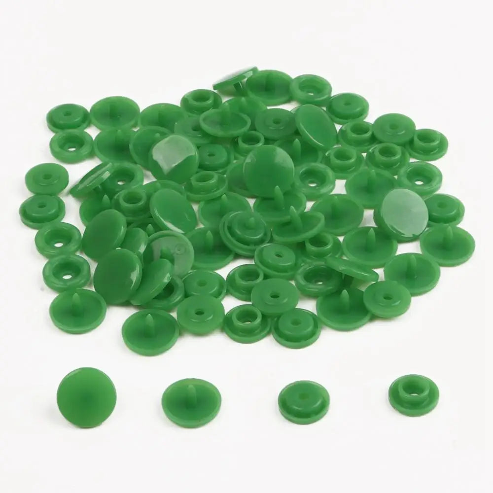 A pile of assorted green snap buttons, measuring 12mm and 10.5mm, for crafting.
