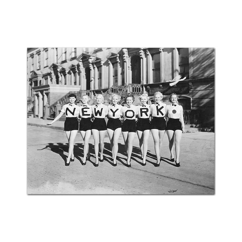 Black and white photograph of a group of women dressed in flapper style posing in front of a large building.