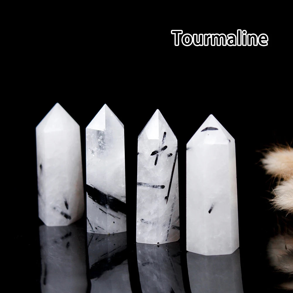 Four white tourmaline crystal points displayed against a black background.