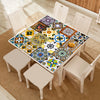 A wooden table displays a colorful mosaic of retro Moroccan tile stickers on a light-colored rug.