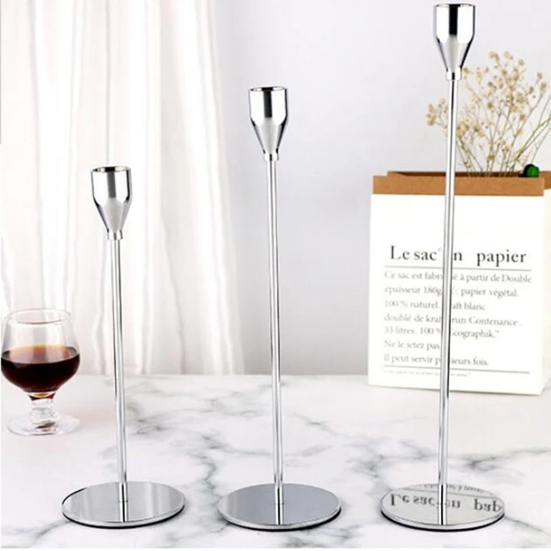 A silver European style iron candle holder standing on a marble surface.