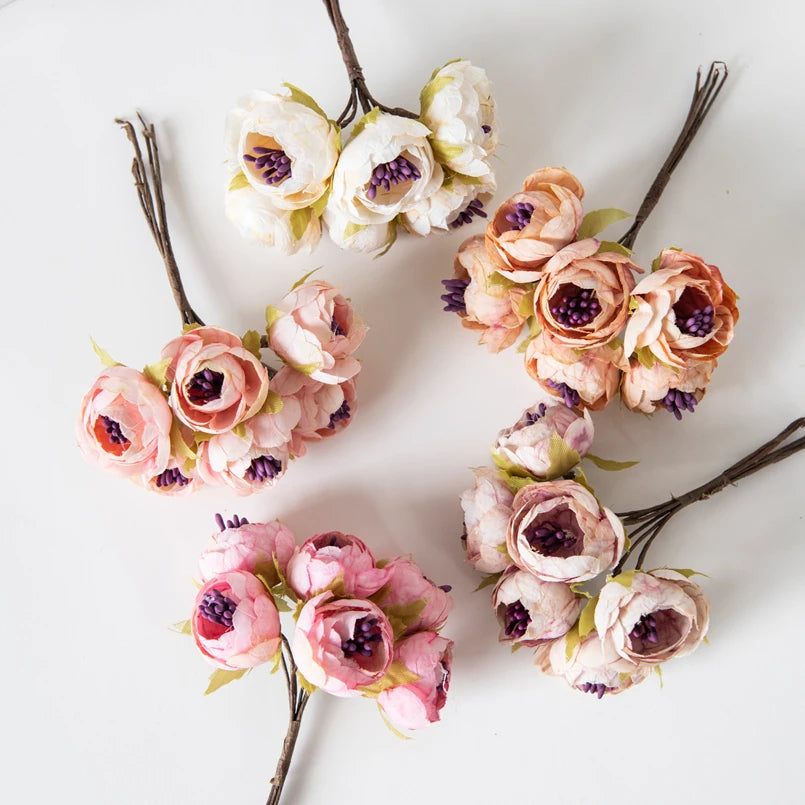 Zarte Girlande aus künstlichen Seerosen in zarten Rosa- und Cremetönen auf weißem Hintergrund.