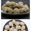A display of natural desert rose selenite stones piled on a dark plate.