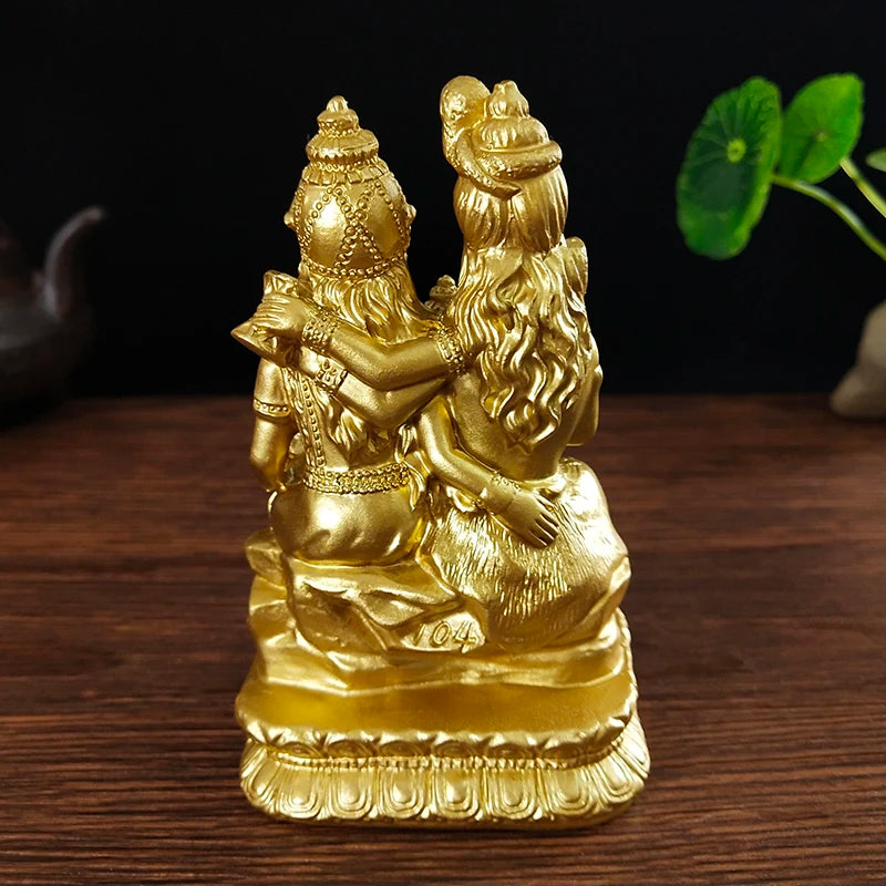 Gold resin figurine of a Hindu or Buddhist deity with long hair and ornate crown sitting in a meditative pose.