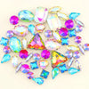 A mix of iridescent glass rhinestones in various colors including pink, blue, green, and purple.