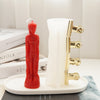 A red silicone mold of a realistic human figure stands next to a clear plastic mold with gold-colored tools on a white base.