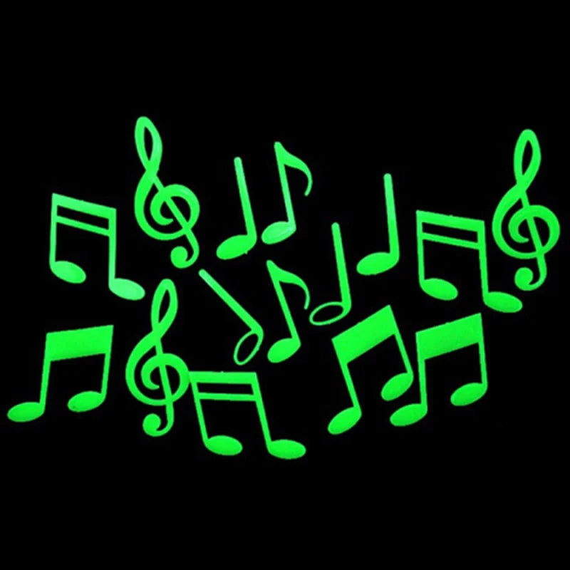 A set of glow-in-the-dark musical notes shaped like stars and moons against a black background.