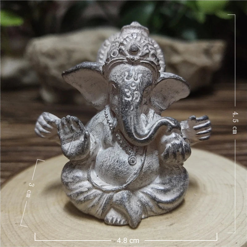 Handcrafted Buddha statue in gray stone texture sitting on a wooden surface.