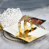Gold pearl laser cut wedding invitations featuring intricate white lace and gold accents on a white card.