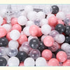 A large plastic container filled with a variety of colorful, clear, and opaque balls for play.